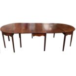 A REGENCY PERIOD MAHOGANY D END DINING TABLE With three extra leaves, raised on twelve chamfered