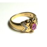 A 9CT GOLD AND PINK SAPPHIRE RING Having a single oval cut sapphire flanked with white sapphires (