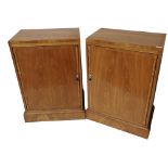 A PAIR OF EARLY 20TH CENTURY BLOND MAHOGANY SIDE CABINETS With single doors, on plinth bases. (