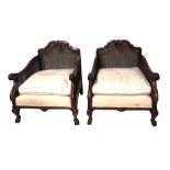 A PAIR OF EARLY 20TH CENTURY MAHOGANY BERGÈRE CHAIRS With double caned sides, carved with shells and