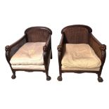 A PAIR OF EARLY 20TH CENTURY MAHOGANY BERGÈRE ARMCHAIRS With double canes back and sides, carved