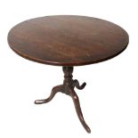 A GEORGIAN OAK AND ELM TILT TOP OCCASIONALLY TABLE The circular top with tripod legs and pad