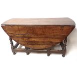 A 17TH/18TH CENTURY OAK GATE LEG OVAL TABLE With two drawers raised next square and turned legs. (