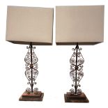 A LARGE PAIR OF WROUGHT IRON TABLE LAMPS with pierced scroll work on stepped platforms 96 cm