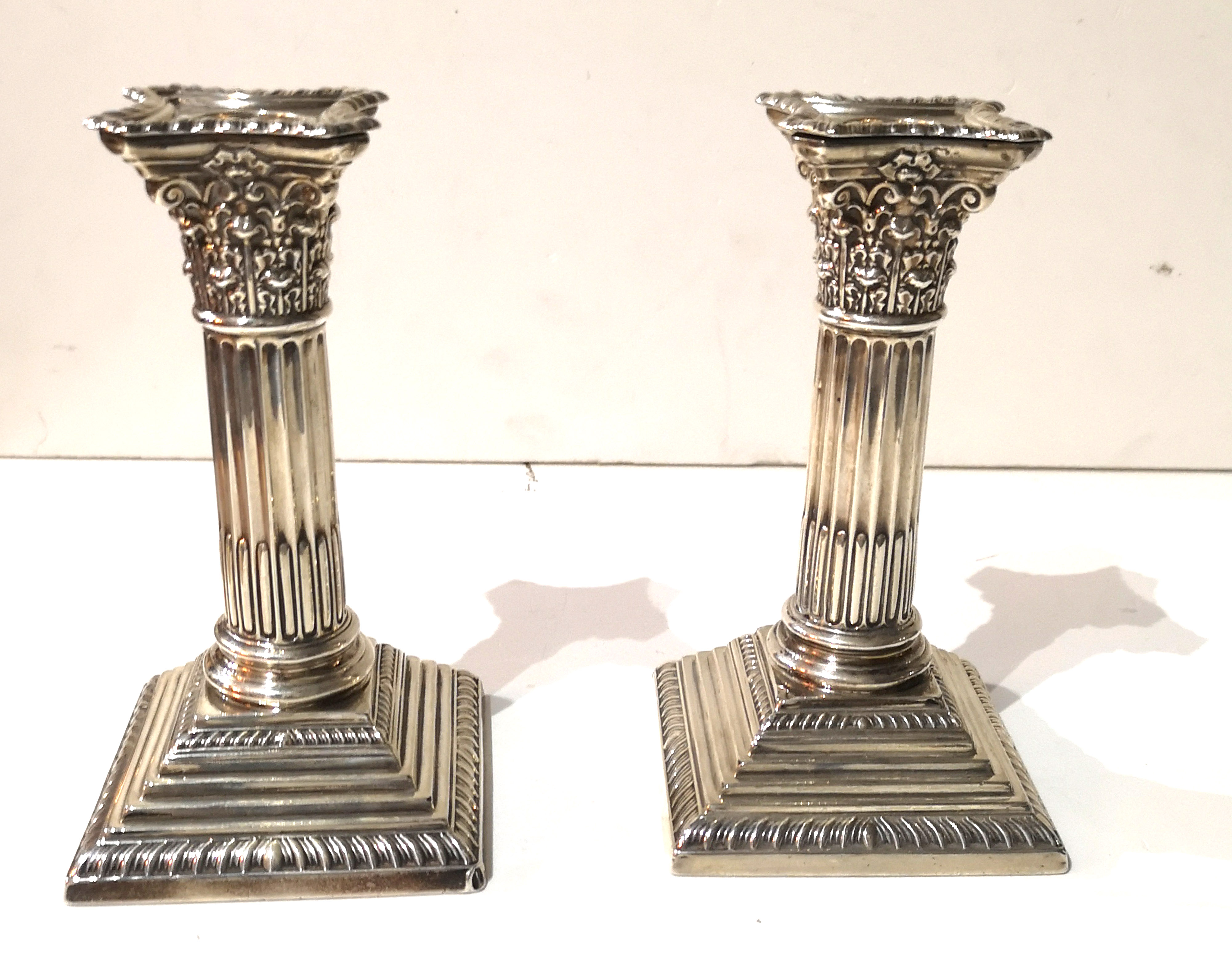 A PAIR OF EDWARDIAN SILVER CANDLESTICKS Classical column form, on a stepped square base,