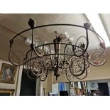 A LARGE SIXTEEN BRANCH IRON CHANDELIER With scroll work branches W183 x D112 cm