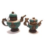 TWO INDIAN BRASS TURQUOISE AND CORAL TEAPOTS Having a figural handle and spout and an embossed