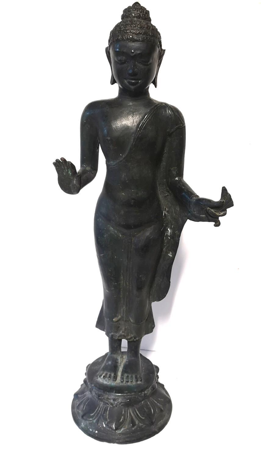 A CHINESE BRONZE STATUE OF A STANDING BUDDHA Patinated finish with one palm hand showing, raised