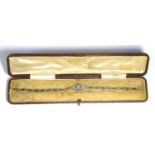 A FINE ART DECO BICOLOUR 18CT GOLD, DIAMOND AND EMERALD BRACELET Having a row of three round cut