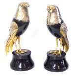 A PAIR OF CERAMIC AND WHITE METAL CLAD BIRD SCULPTURES Birds of prey with black ceramic body, on