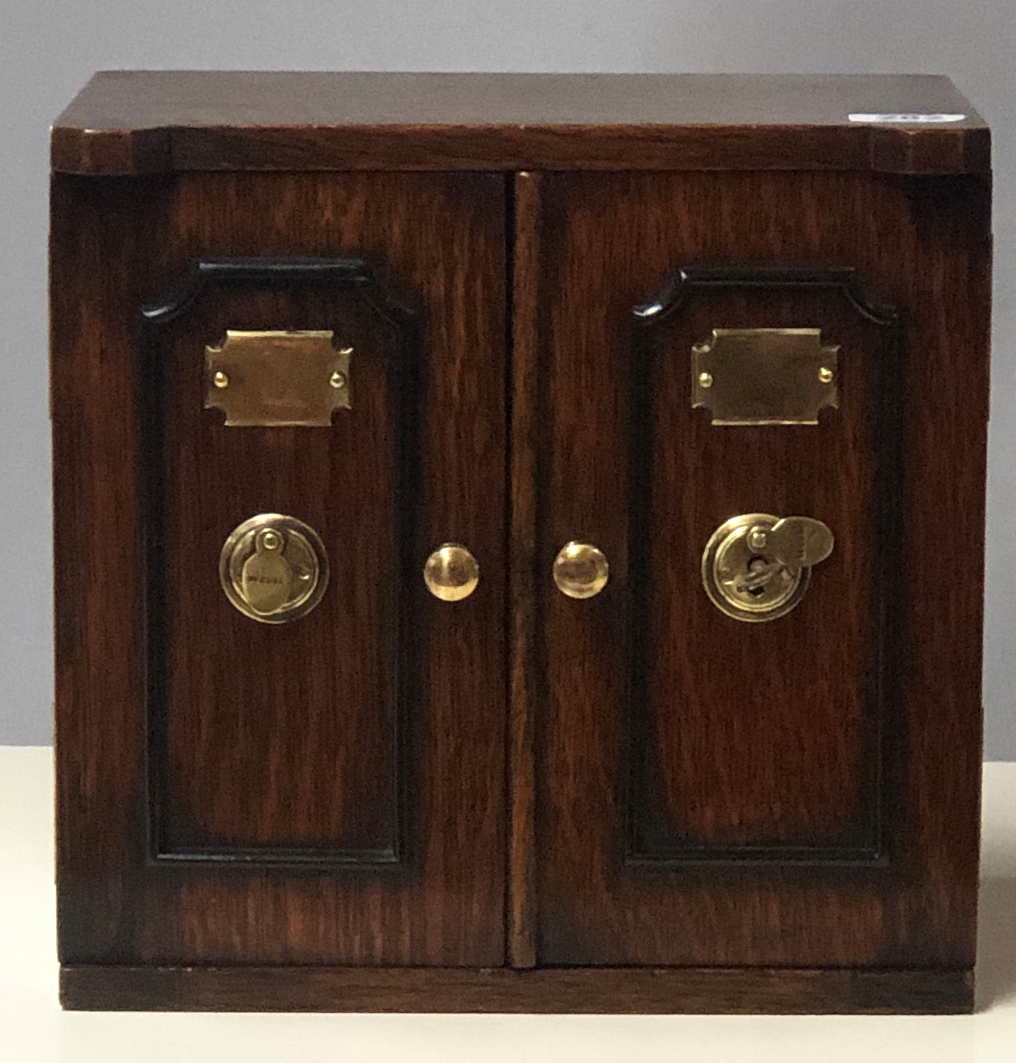 AN EARLY 20TH CENTURY OAK TABLE TOP COLLECTOR'S CHEST In the form of a safe, the two doors with