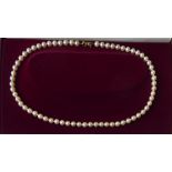 A 9CT GOLD AND PEARL NECKLACE The single strand of cultured pearls with a bow form gold clasp. (