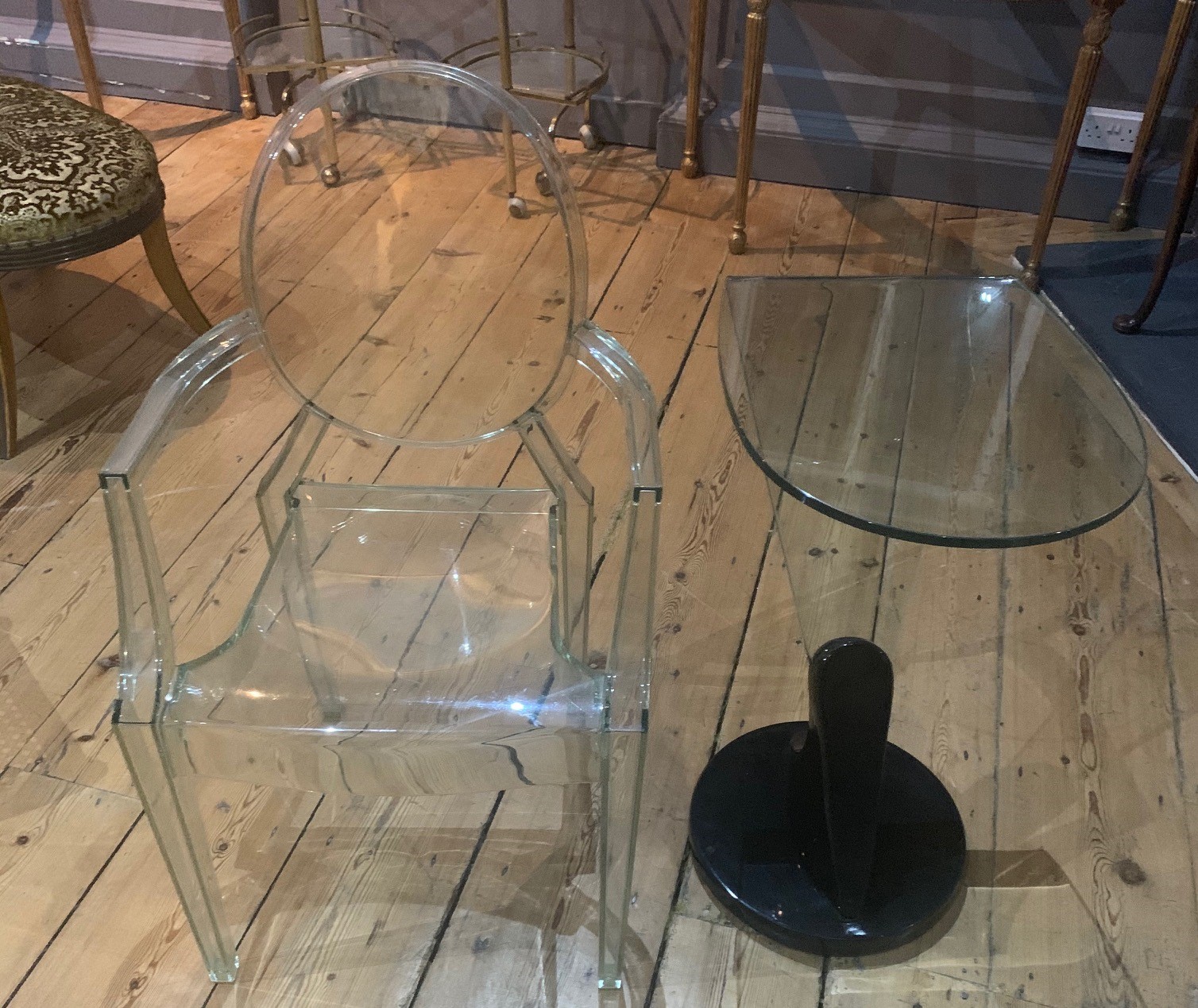 A DESIGNER GLASS TABLE Along with Philip Stark Perspex chair. (40cm x 50cm x 72cm)