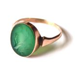 A LATE 19th/EARLY 20TH CENTURY YELLOW METAL AND HARD STONE INTAGLIO SIGNET RING Having an oval green