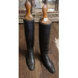 A PAIR OF EARLY 20TH CENTURY BLACK LEATHER RIDING BOOTS With wooden trees (size 6).