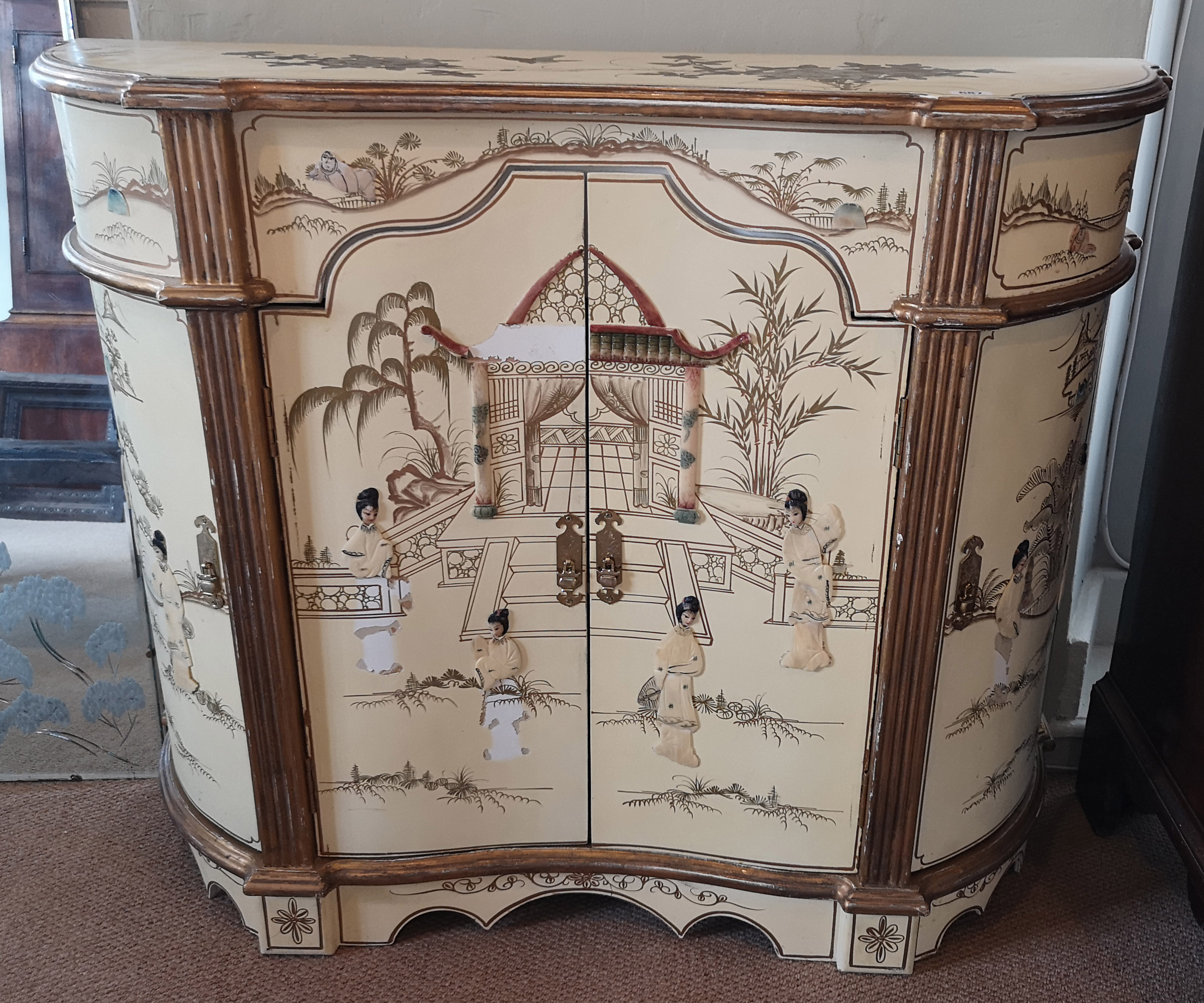 A 20TH CENTURY SIDE CABINET With japanned decoration on a cream ground, the inverted bow front