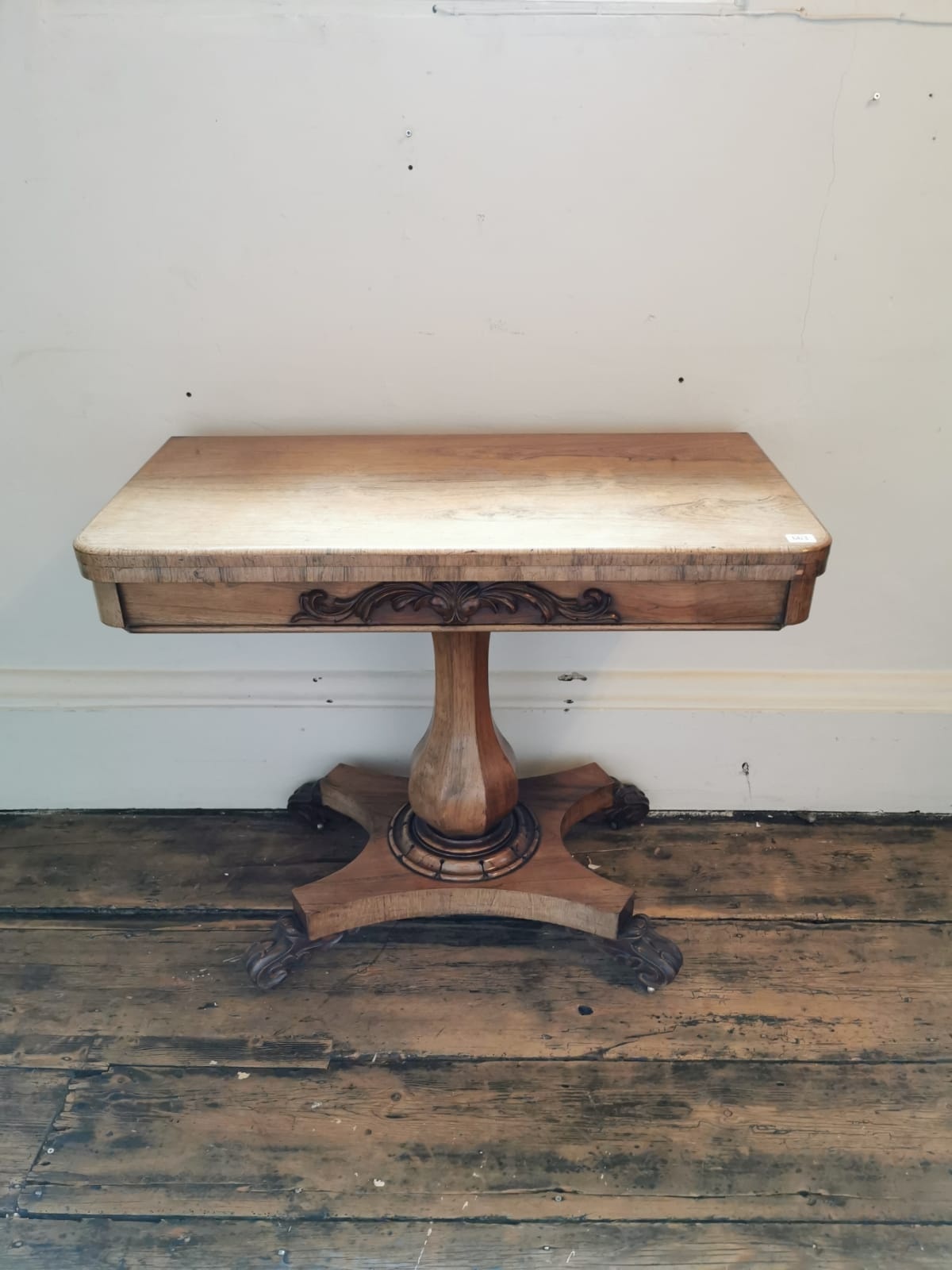 A WILLIAM IV BLEACHED ROSEWOOD FOLD OVER CARD TABLE With red circular playing surface raise on a