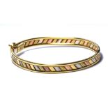 A VINTAGE 9CT TRICOLOUR GOLD BANGLE Chevron design of alternate tone gold. (approx 6cm)