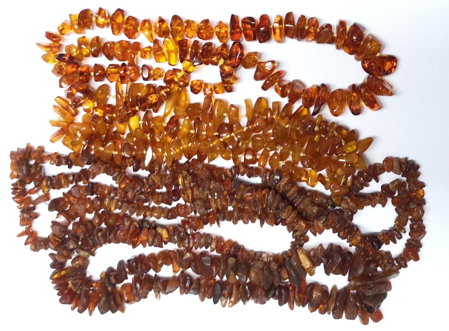A COLLECTION OF FOUR AMBER NECKLACES Orange shard form. (approx 40cm)