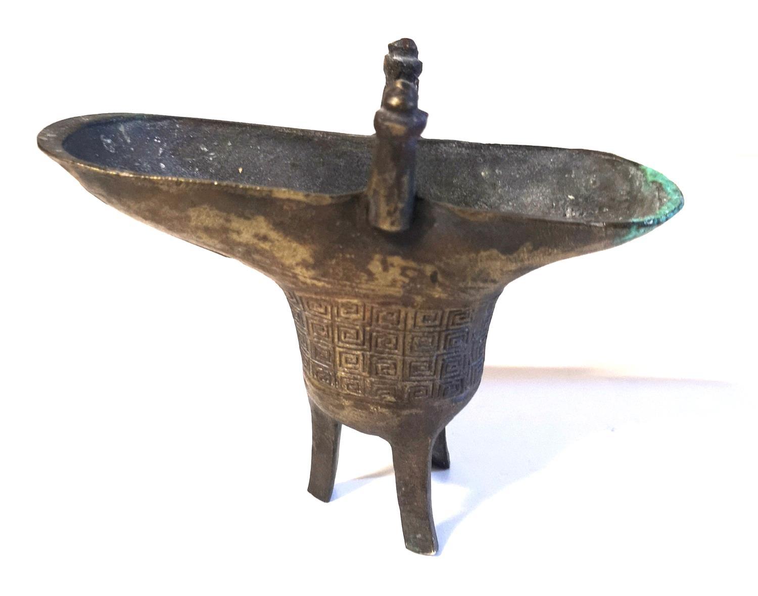 A CHINESE ARCHAIC FORM BRONZE OVAL EWER With geometric decoration and tripod legs, bearing a '