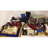 A COLLECTION OF MASONS REGALIA Including gilt medallions, aprons, sashes cuffs and books.