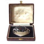 AN EARLY 20th CENTURY CASED WHITE METAL AND BLOODSTONE SCARF CLIP An oval cabochon cut stone in a