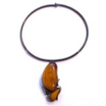 A VINTAGE SILVER AND AMBER NECKLACE Two oval form oval beads on a plain silver necklace. (approx