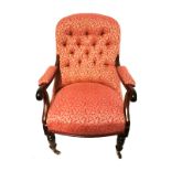 A VICTORIAN MAHOGANY OPEN ARMCHAIR In button back floral upholstery on a cerise ground, raised on