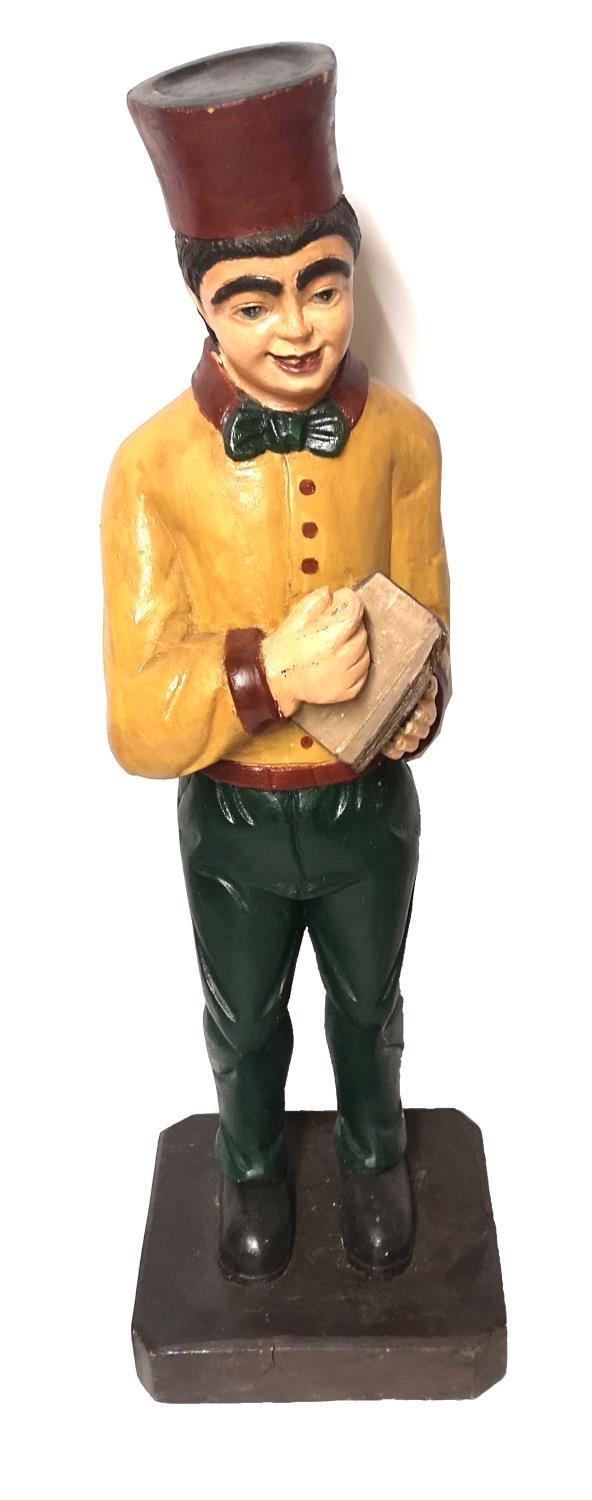 AN EARLY 20TH CENTURY AMERICAN CARVED AND PAINTED WOODEN FIGURE OF A WAITER/BELL BOY. (h 96cm)