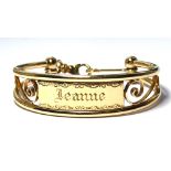 A VINTAGE 9CT GOLD IDENTITY BANGLE Heavy gauge with scrolled design, inscribed 'Leanne'. (approx