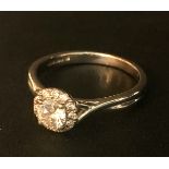 AN 18CT WHITE GOLD RING, daisy set, with the central diamond. 0.31ct. size K/L.