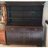 A 19TH CENTURY OAK DRESSER With open shelves above an arrangement of six drawers and cupboards, on