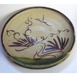 A JAPANESE ORIBE POTTERY PLATE Having a shallow rim and hand painted decoration Approx 22cm