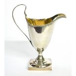 A GEORGIAN SILVER CLASSICAL HELMET FORM CREAM JUG With beaded rim and gilt interior, hallmarked