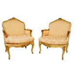 A PAIR OF EARLY 19TH CENTURY FRENCH GILTWOOD FRAMED ARMCHAIRS The shaped back rail centre with a