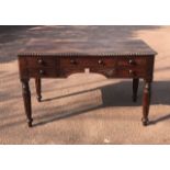 AN EARLY VICTORIAN SOLID ROSEWOOD WRITING TABLE With an arrangement of five drawers, raised on
