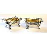 A PAIR OF GEORGIAN SILVER SALTS Having shell and gadrooned border with lion paw feet and gilt