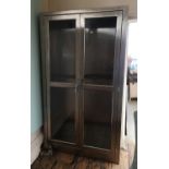A STAINLESS STEEL CUPBOARD With two glazed doors.