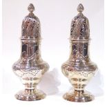 A PAIR OF GEORGE II SILVER CASTERS Having pierced dome form lids with pineapple finials and scrolled