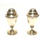 A PAIR OF GEORGIAN SILVER BALUSTER PEPPERETTES With pierced dome and reeded border, hallmarked James
