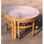 A NEST OF FIVE MID 20TH CENTURY TEAK TABLES The circular top with inset glazed top above