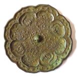 A CHINESE BRONZE MIRROR Archaic style with embossed decoration. (approx diameter 21cm)