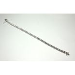 AN 18CT WHITE GOLD TENNIS BRACELET Set with 10.6ct round cut diamonds. (length 19cm) (12.9g)