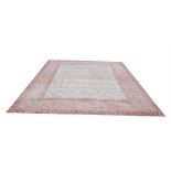 AN INDIAN AGRA RUG OF CARPET PROPORTIONS The central floral field on a beige ground contained within