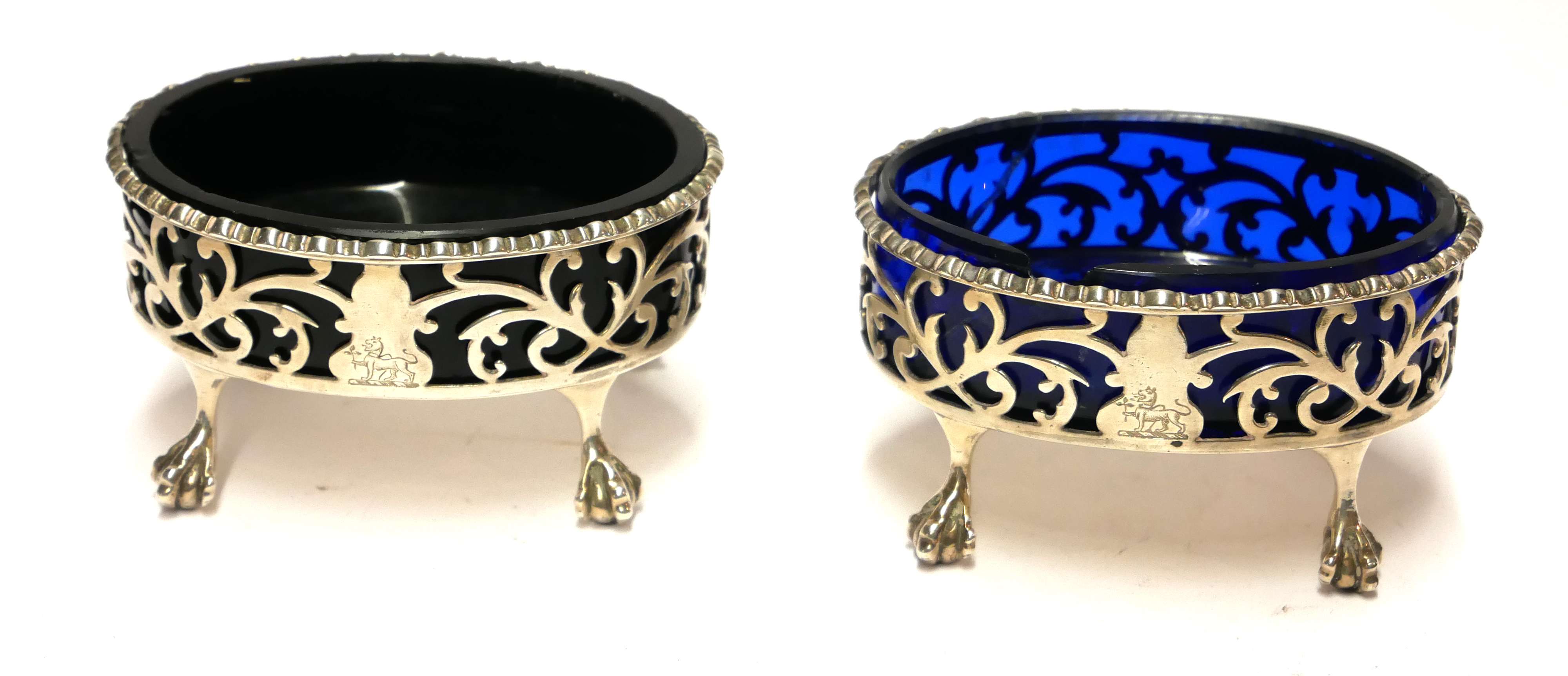A PAIR OF GEORGIAN SILVER AND BLUE GLASS OVAL SALTS With pierced scrolled decoration raised on eagle