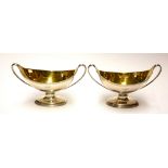 A PAIR OF GEORGIAN SILVER NAVETTE FORM SALTS With twin handles and gilt interior and engraved