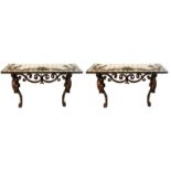 A PAIR OF WROUGHT IRON AND GILT EMBELLISHED CONSOLE TABLES With painted mirrored tops above scroll