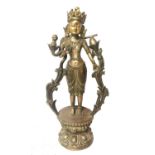 A LARGE TIBETAN BRONZE FIGURE OF A DEITY Standing on a lotus flower base, the collar set with