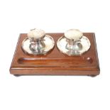 AN EARLY 20TH CENTURY SILVER AND MAHOGANY DESK INKSTAND Two spherical inkwells on a fitted