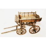 A 19TH CENTURY DOG CART With spindle rails, on four iron bounds spoked wheels. (136cm x 59cm x 74cm)